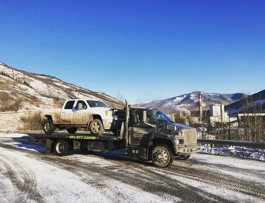 Camo Tow hauling a pickup on a winter highway